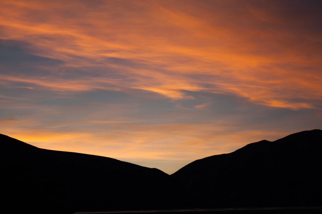 silhouette of mountain under orange sky