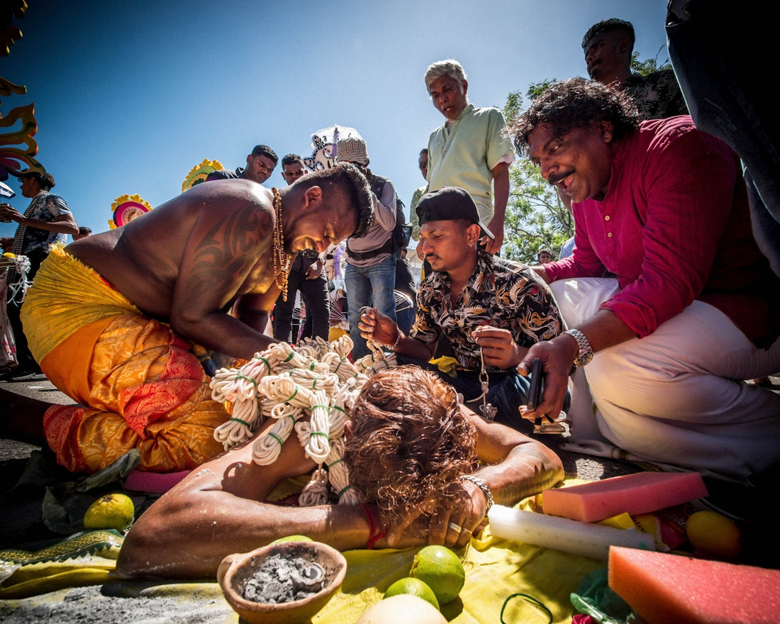 a group of people standing around a woman laying on the ground