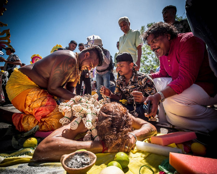 a group of people standing around a woman laying on the ground