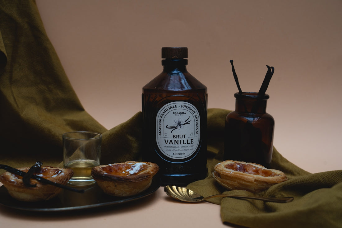 Vanilla extract and pastries sit in a still life.