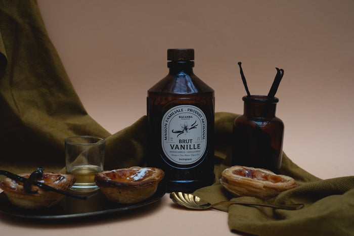 Vanilla extract and pastries sit in a still life.