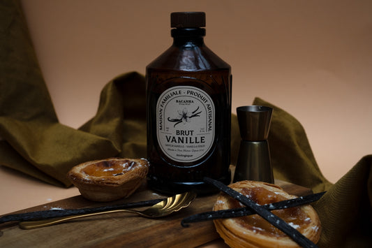 A bottle of vanilla, dessert, and cocktail tools.